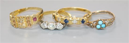 An 18ct gold and three stone diamond ring and three other gem set rings including one 9ct and one 15ct.